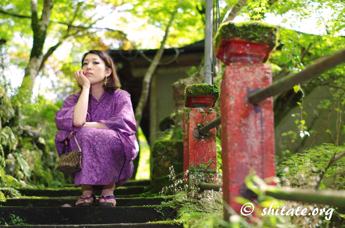 苔の階段で座る紫の浴衣女性